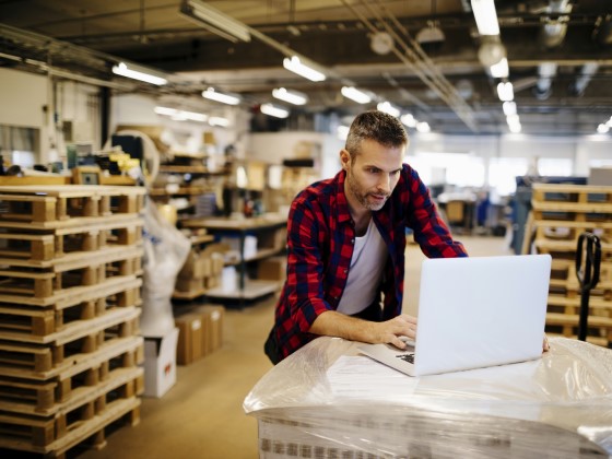 Unternehmer verwaltet sein Lager am Laptop