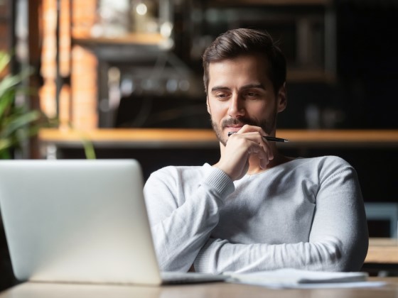 Kleinunternehmer sitzt nachdenkend vor dem Laptop